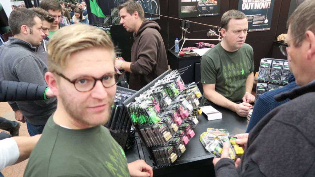 Das Bild zeigt einen Angelexperten am Korda Messestand auf der Angelmesse Carp austria, der günstig Angelzubehör verkauft. Angelausrüstung auf er Karpfenfischen Messe zu kaufen hat viele Vorteile gegen Angelzubehoer-online-kaufen