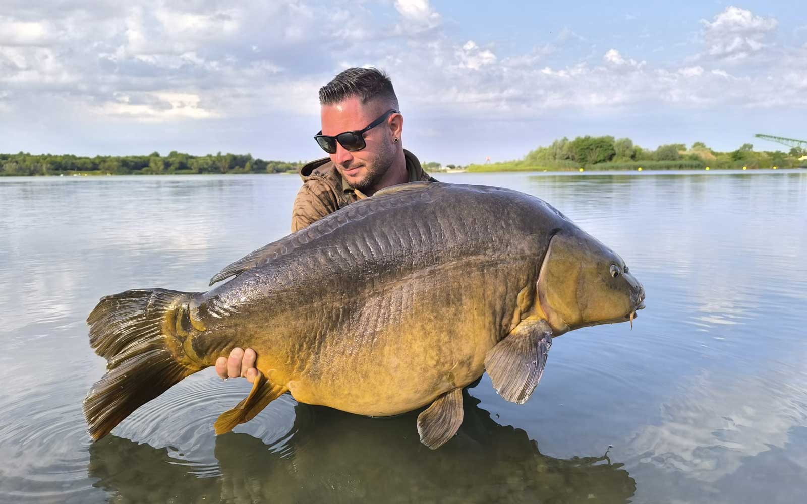 Karpfenangler mit großem Spiegelkarpfen im M’NATURA-Baits Markenprofil