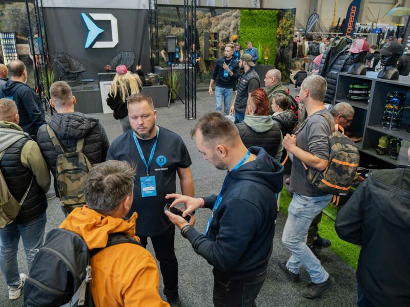 Großer Delphin Fishing Messestand mit Logo, Angelruten, Angelzubehör und vielen Besuchern