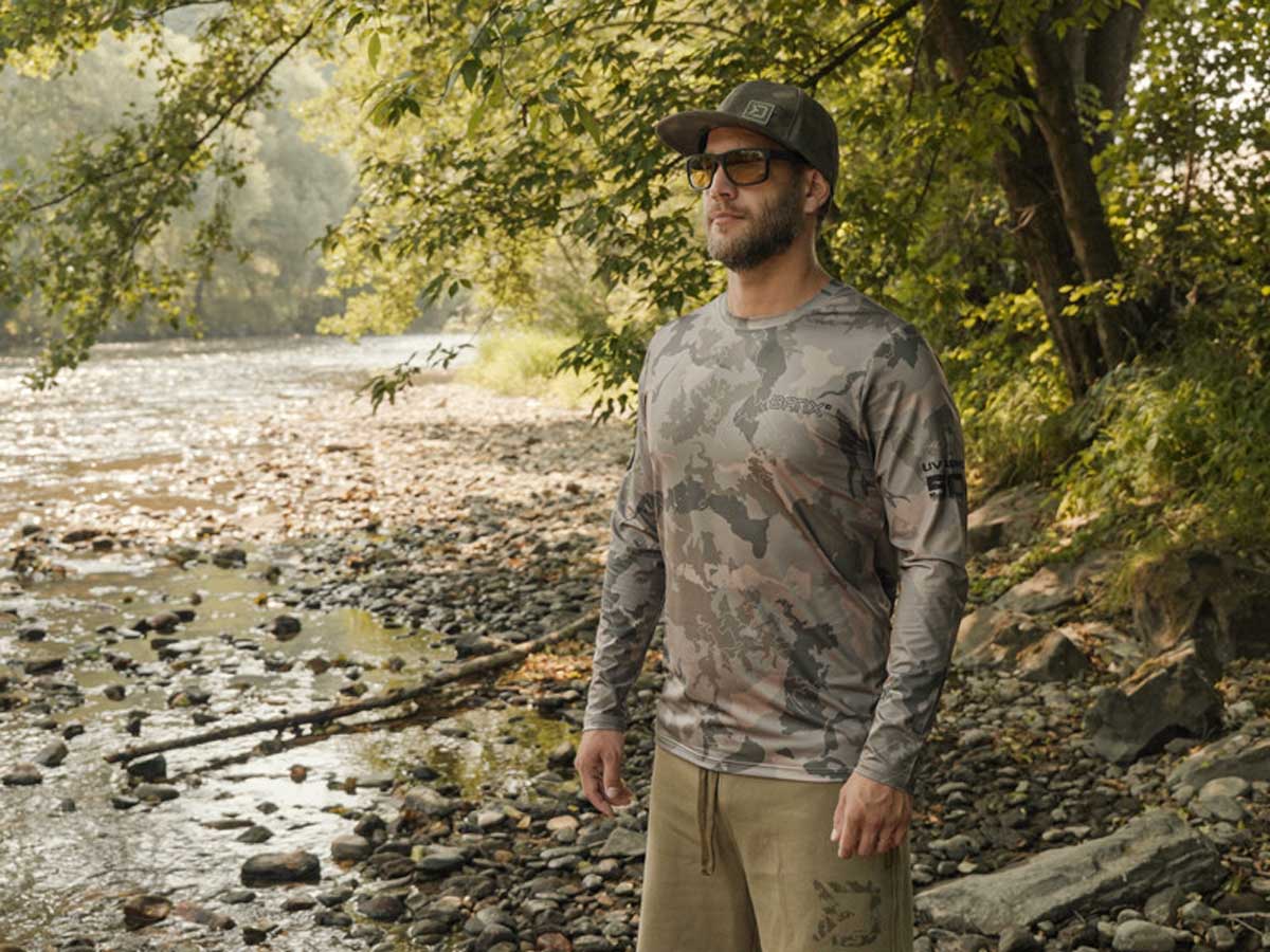 Angler im Delphin UV ARMOR BANX Shirt mit UPF 50+ am Flussufer