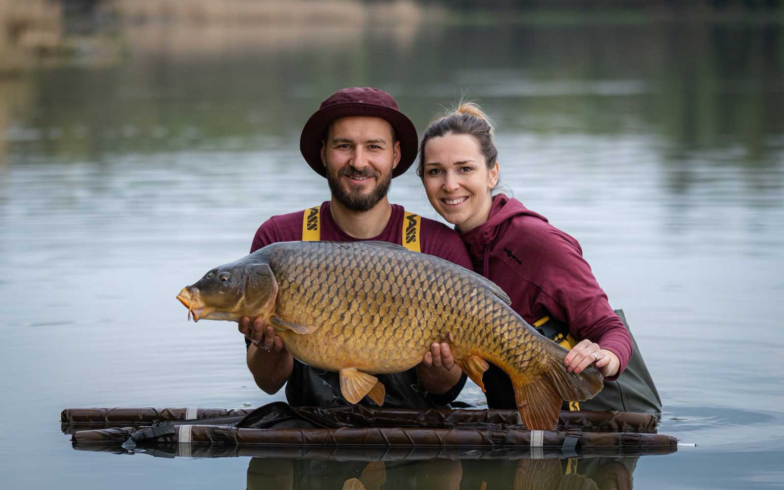 Zwei Karpfenangler mit großem Karpfen am Wasser bei Katlov Lakes