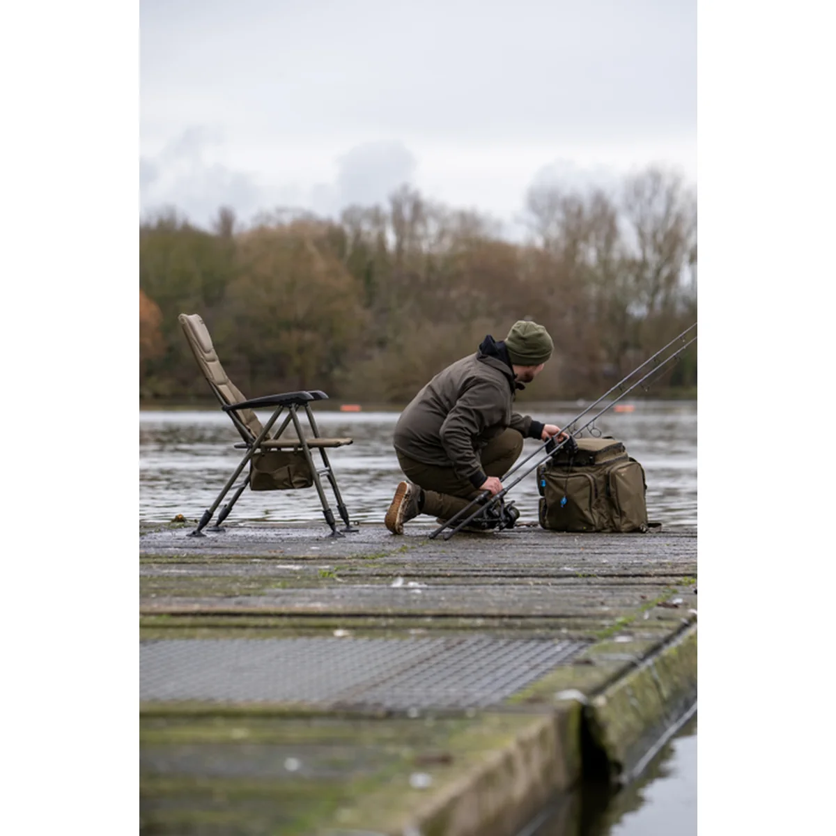 Angler auf einem Avid-Carp-Revolve-X-Armchair an einem Angelsteg